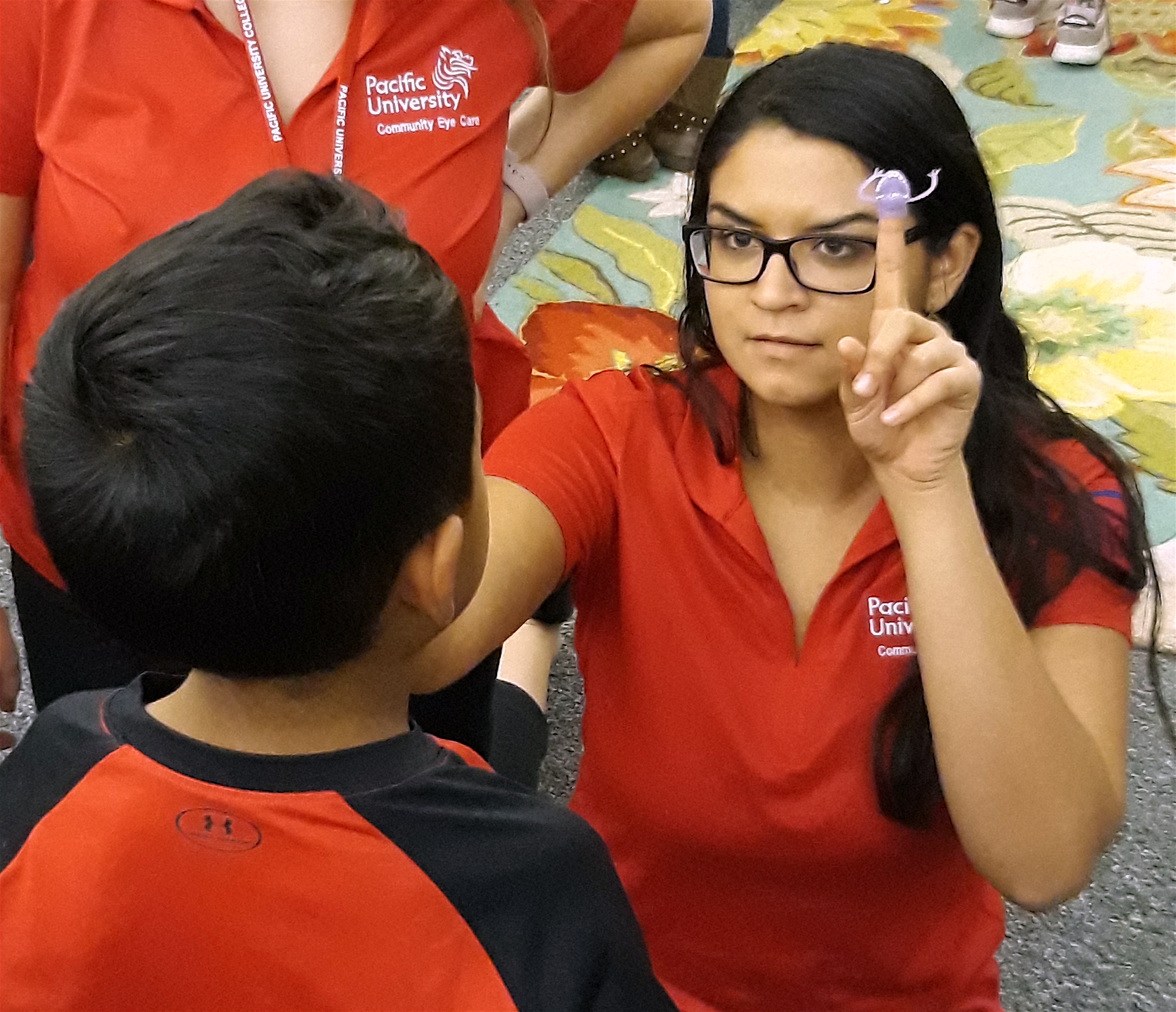 Optometry student giving a child an eye exam