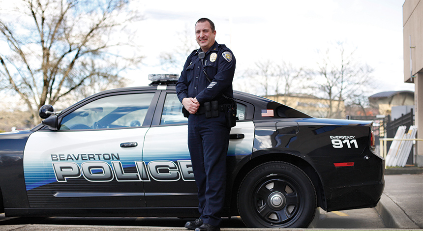 Jeffrey posing in front of the police car.