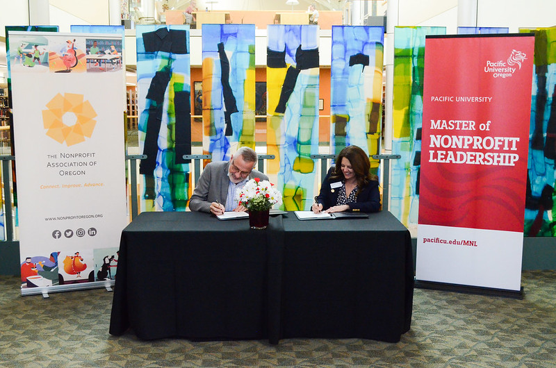 俄勒冈非营利协会 Executive Director Jim White and Pacific University President Jenny Coyle sign a partnership agreement at a celebration at Pacific