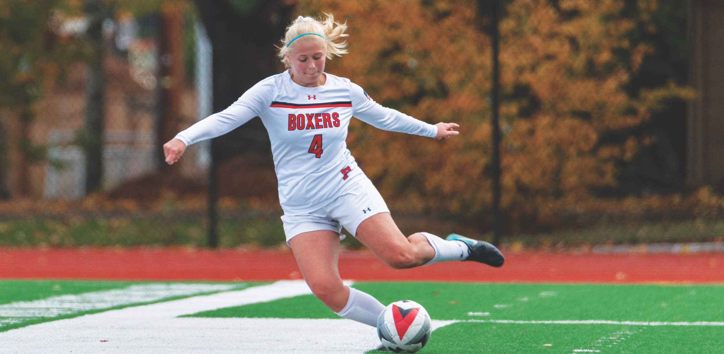 female Pacific player kicking soccer ball