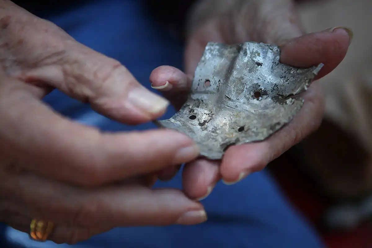 person holding shrapnel piece