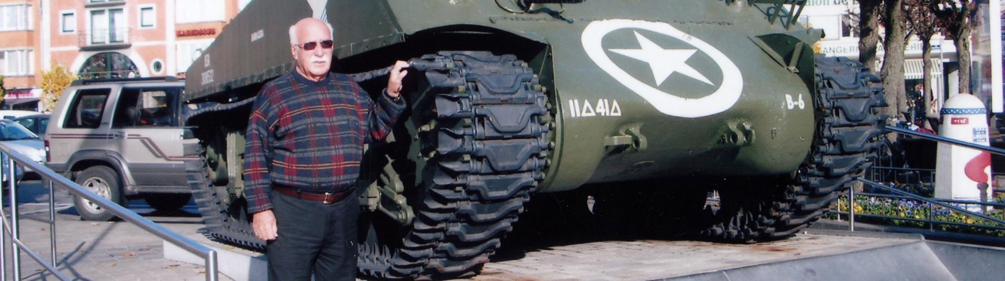 Calvin Van Pelt poses by an American Sherman M-4 tank, the same type he commanded, displayed at Bastogne, France.