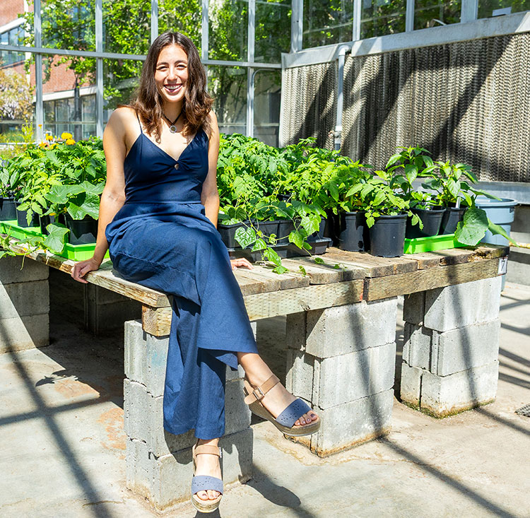 Valentina Casab-Klescova '25 sitting inside Pacific's greenhouse.