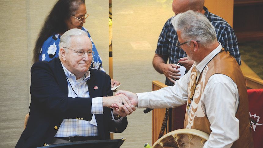 AuCoin accepts thanks from Jon George, a member of the Grand Ronde Tribal Council, at Pacific University.