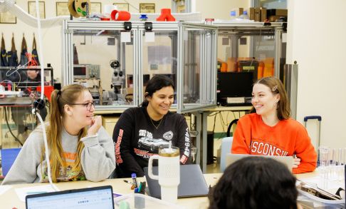 Three students work at a table in the Boxer Makerspace. 