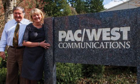 Paul and Nancy Phillips posing in front of PacWest Communications.