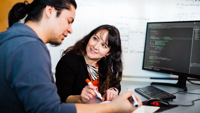 A computer science professor instructs a student through a coding problem.