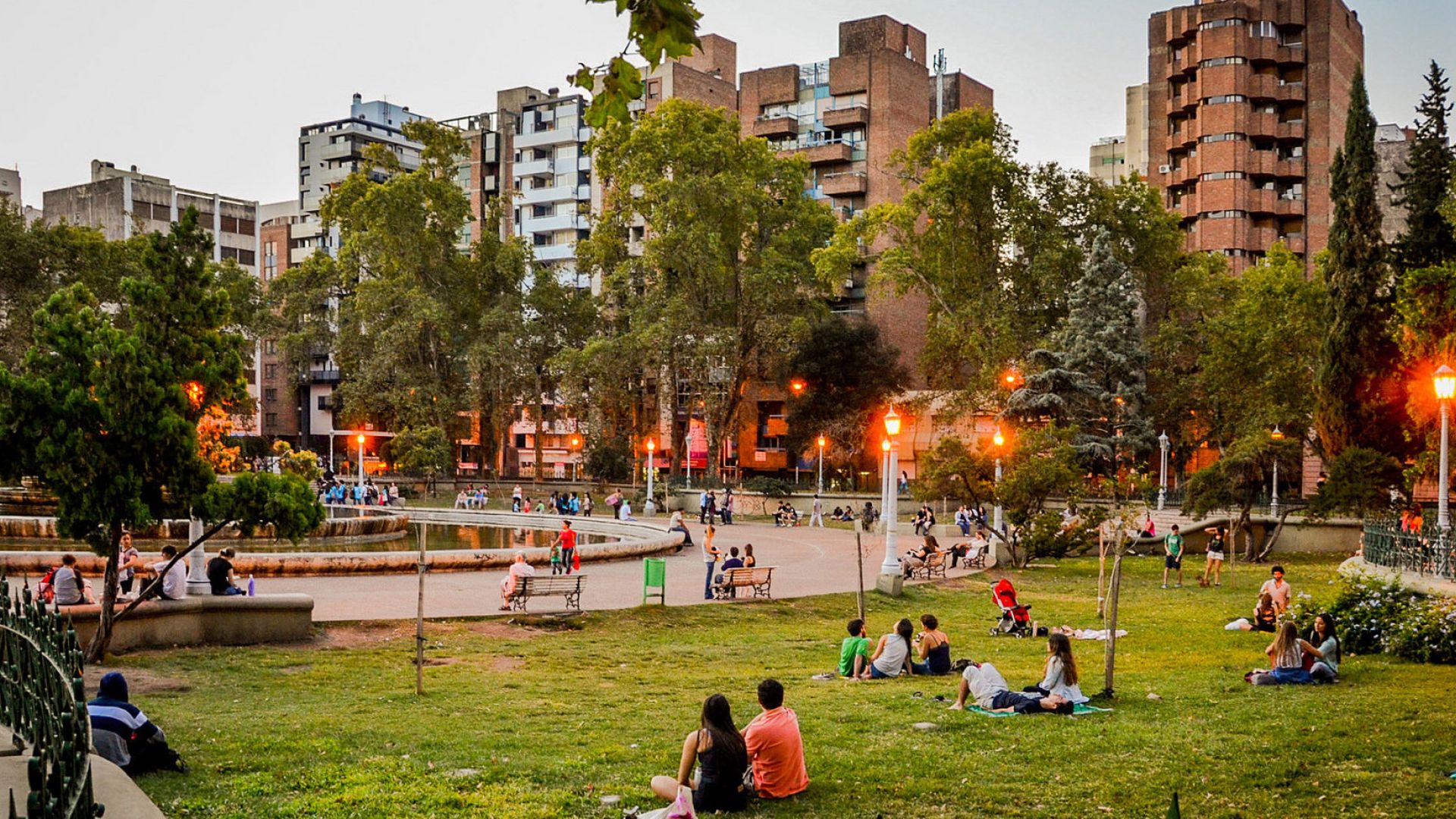 People sitting on the grass in a city park of Cordoba