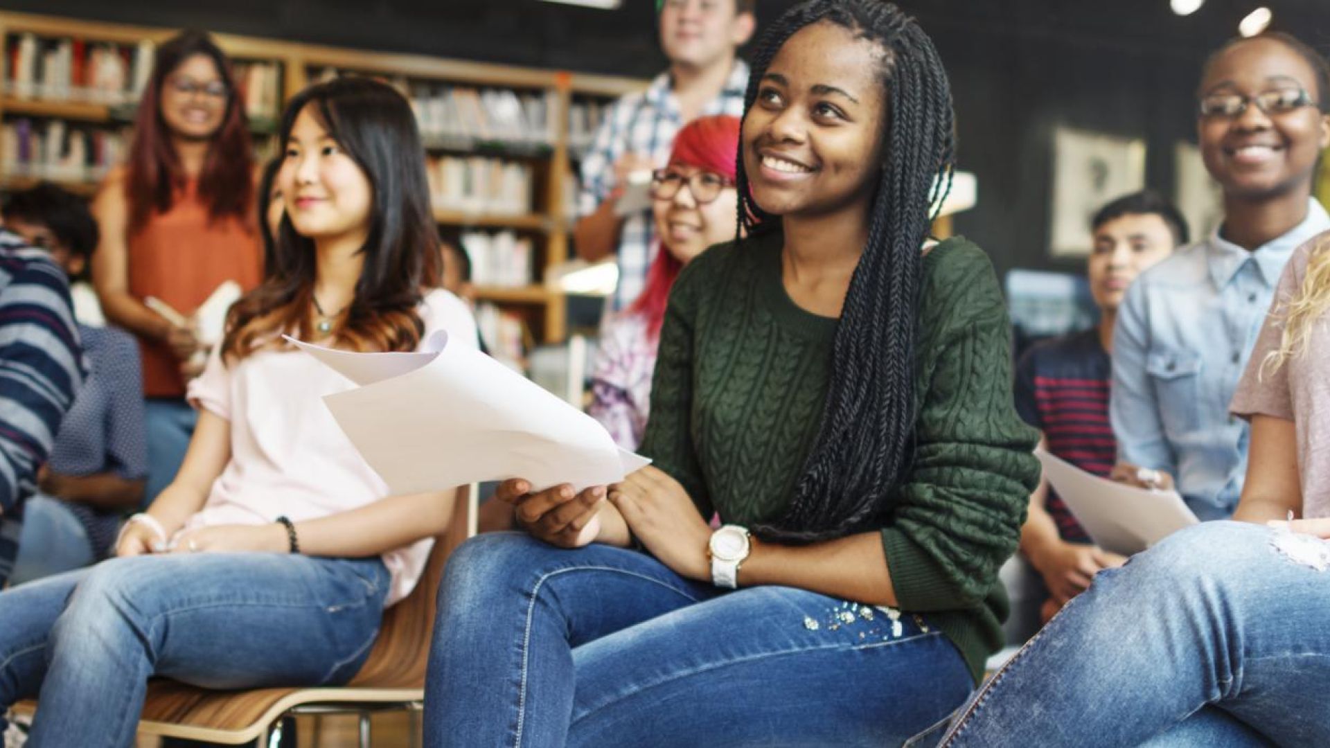 Several students sitting in a classroom smiling