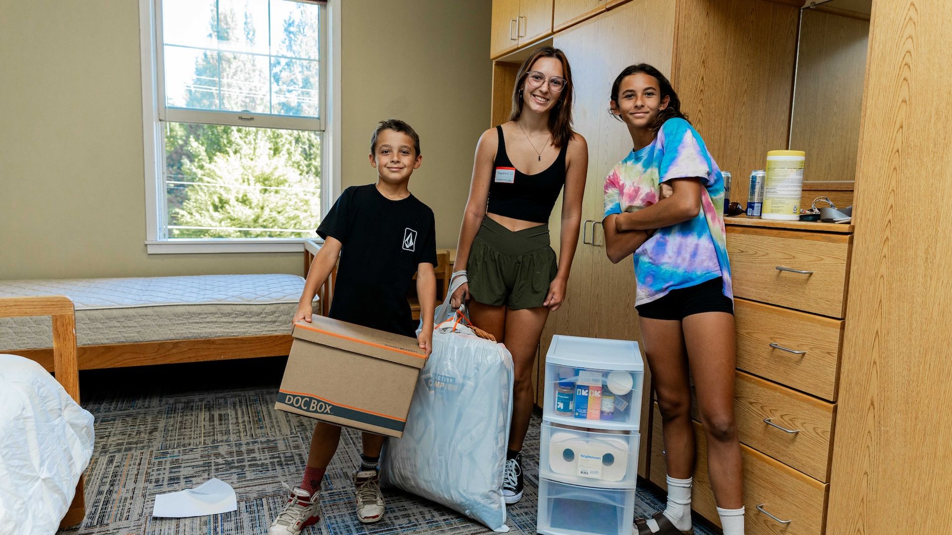 Pacific students and younger sibling moving into a residence hall room