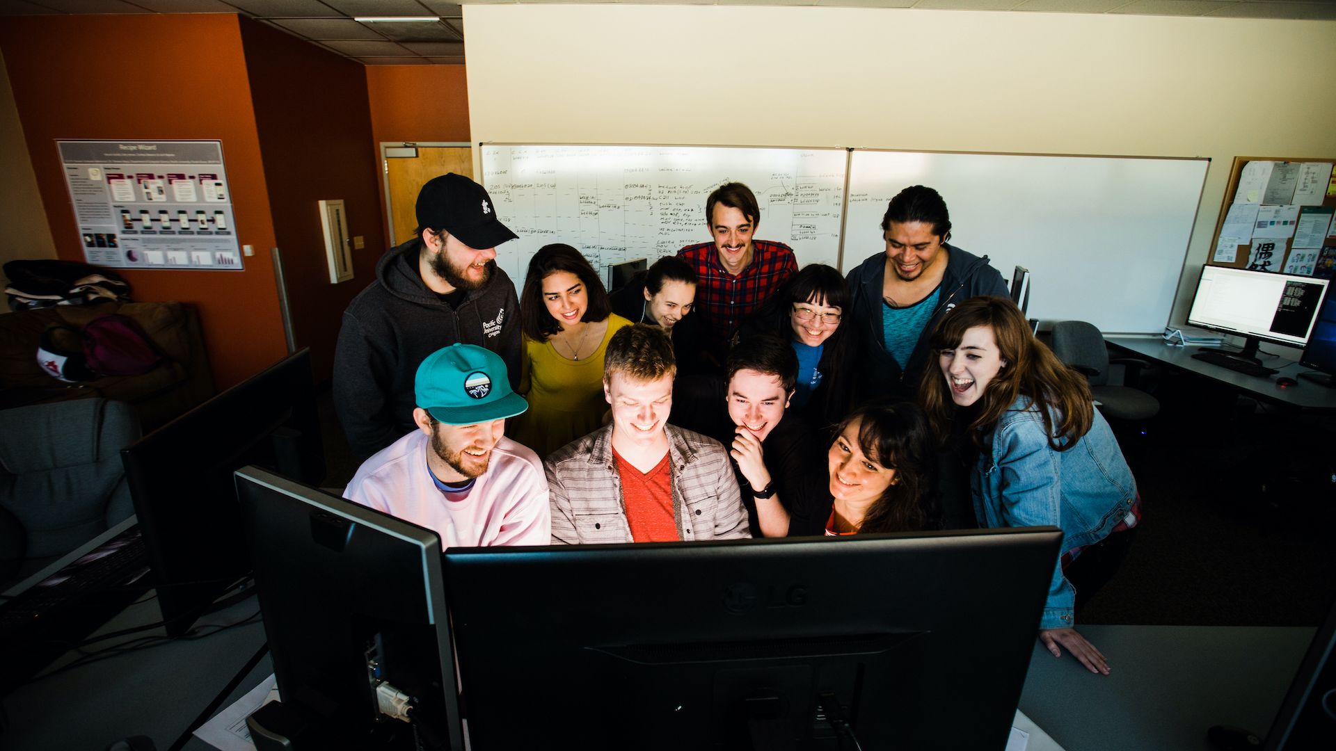 Group of students working in front of two monitors