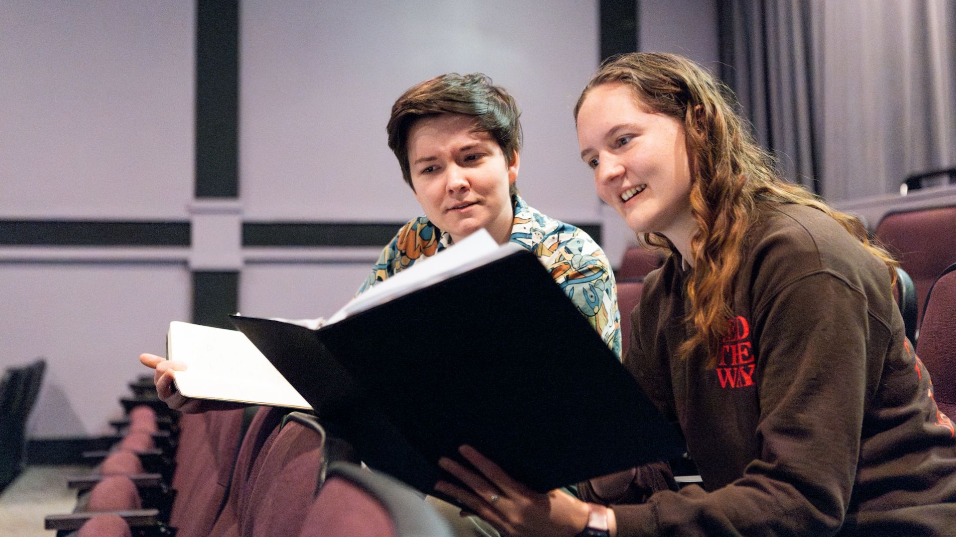 Pacific staff and students reviewing script in theatre seats